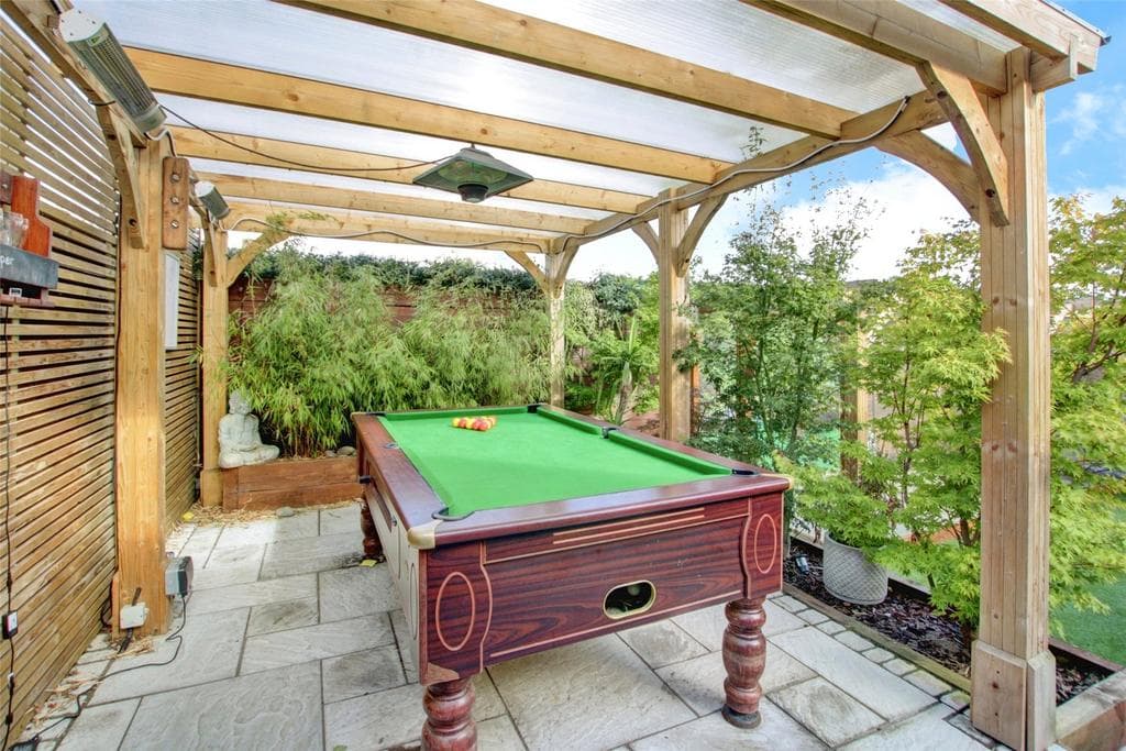 Outdoor pool table under pergola